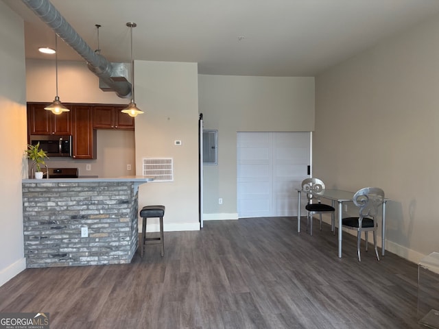 502 Pryor St SW Unit 301, Atlanta, GA 30312 - kitchen with stainless steel microwave, dark wood-type flooring, hanging light fixtures, light countertops, and a breakfast bar area