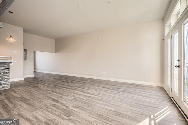 unfurnished living room featuring baseboards and wood finished floors