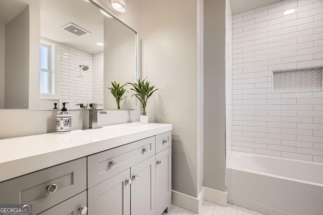 bathroom featuring tile patterned flooring, visible vents, baseboards, shower / bathtub combination, and vanity