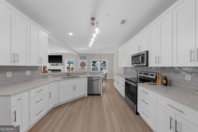 236 Village Park Dr, Newnan, GA 30265 - kitchen featuring stainless steel appliances, a sink, light wood-style floors, decorative backsplash, and white cabinets