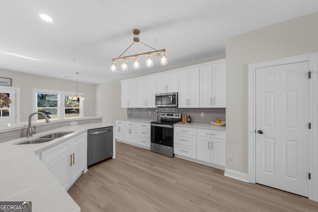 236 Village Park Dr, Newnan, GA 30265 - kitchen featuring stainless steel appliances, a sink, a chandelier, backsplash, and white cabinetry