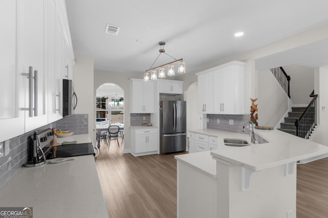 236 Village Park Dr, Newnan, GA 30265 - kitchen with freestanding refrigerator, arched walkways, a peninsula, a sink, and electric range
