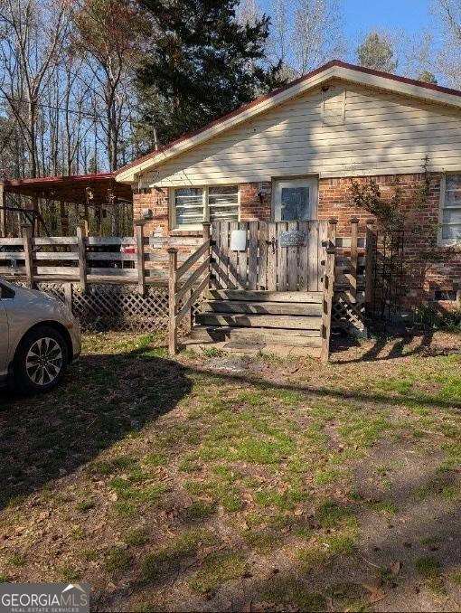view of front of home featuring a wooden deck and brick siding