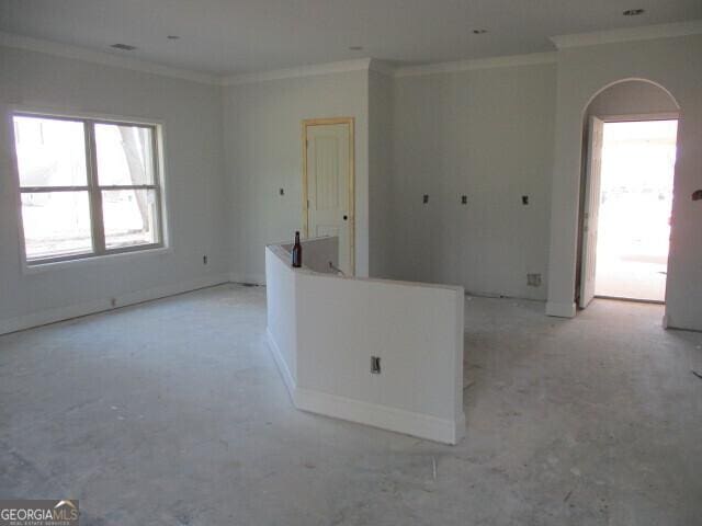 unfurnished room with arched walkways and ornamental molding