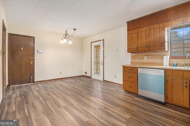 kitchen with dark wood finished floors, a sink, brown cabinets, and dishwasher