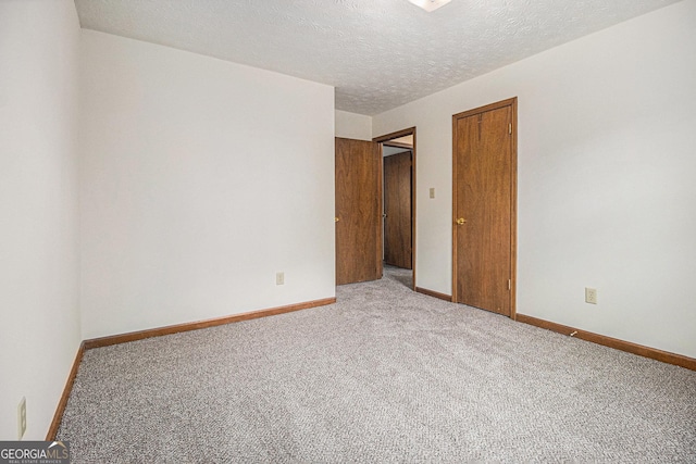 unfurnished bedroom with baseboards, a textured ceiling, and carpet