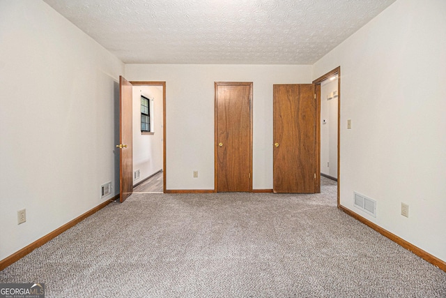 unfurnished bedroom featuring baseboards, visible vents, and carpet flooring