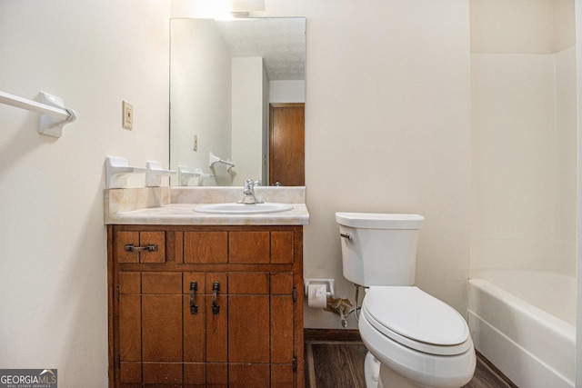 bathroom featuring toilet, vanity, and wood finished floors