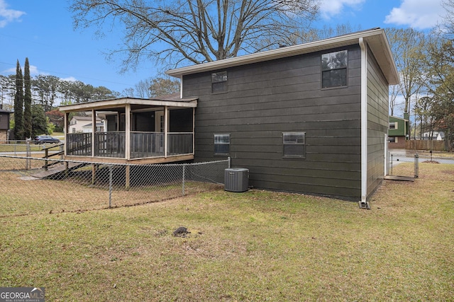 back of house featuring a sunroom, fence, central AC, and a yard