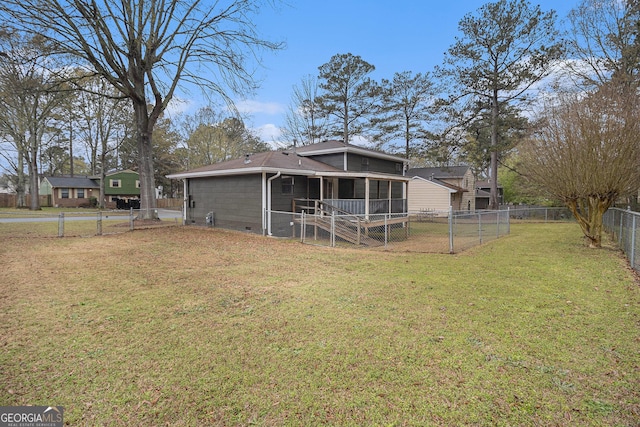 back of property with a fenced backyard, a sunroom, a gate, and a lawn