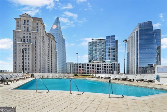 community pool with a patio and a view of city