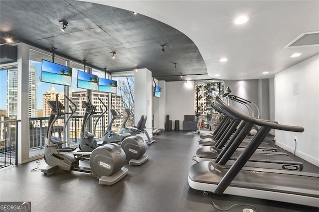 workout area with floor to ceiling windows, recessed lighting, and baseboards