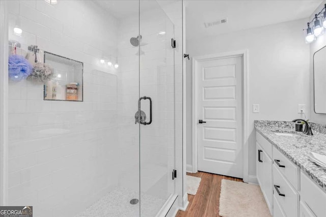 149 Irwin St, Cedartown, GA 30125 - bathroom with a stall shower, wood finished floors, and double vanity