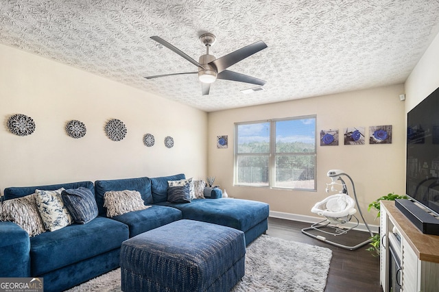 living area with a textured ceiling, visible vents, baseboards, a ceiling fan, and dark wood-type flooring