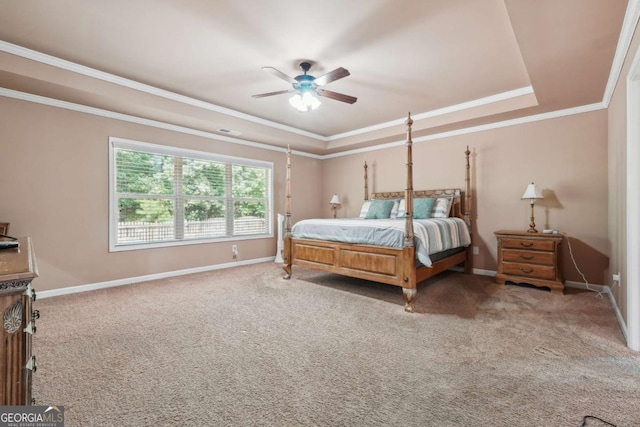 carpeted bedroom featuring baseboards, ornamental molding, a ceiling fan, and a tray ceiling