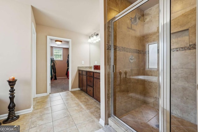 bathroom featuring vanity, baseboards, a shower stall, and tile patterned floors