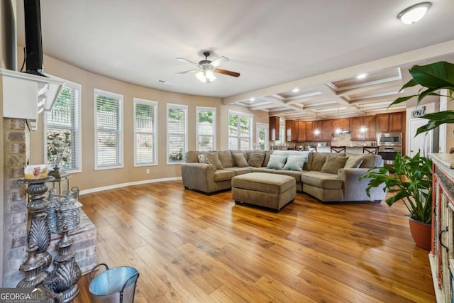 living area with ceiling fan, beamed ceiling, coffered ceiling, recessed lighting, and light wood-style flooring
