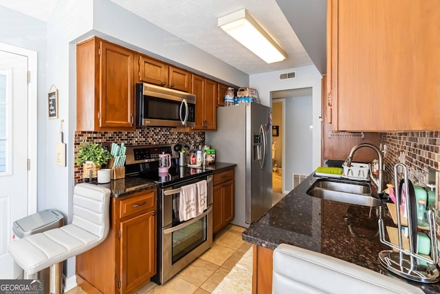 909 Glenleaf Dr, Peachtree Corners, GA 30092 - kitchen with appliances with stainless steel finishes, a sink, decorative backsplash, and dark stone counters
