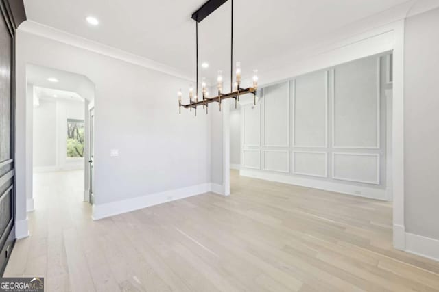 3057 Bold Springs Rd, Dacula, GA 30019 - unfurnished dining area featuring light wood-style flooring, crown molding, a decorative wall, baseboards, and a chandelier