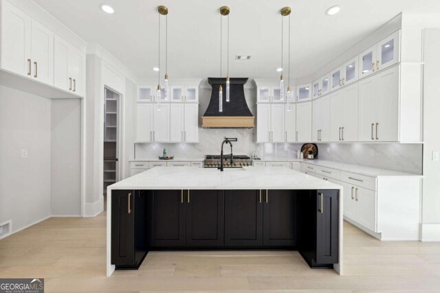 3057 Bold Springs Rd, Dacula, GA 30019 - kitchen with a large island, light wood-type flooring, custom exhaust hood, and white cabinetry