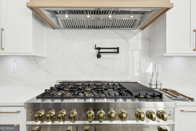 3057 Bold Springs Rd, Dacula, GA 30019 - kitchen view of extractor fan, range, pot filler, and white cabinetry