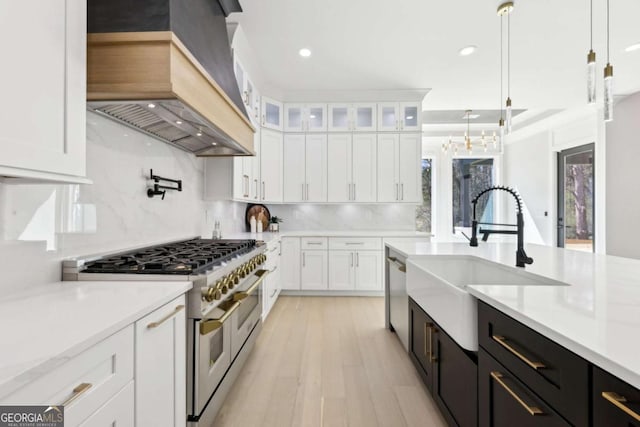 3057 Bold Springs Rd, Dacula, GA 30019 - kitchen with custom range hood, dark cabinetry, white cabinets, stainless steel appliances, and a sink