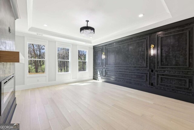 3057 Bold Springs Rd, Dacula, GA 30019 - unfurnished living room with an inviting chandelier, a raised ceiling, and wood finished floors