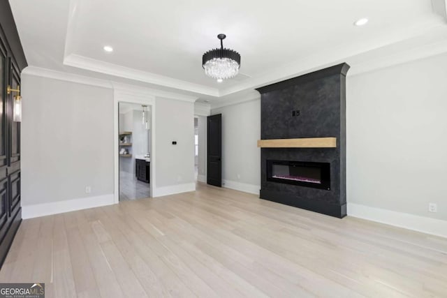3057 Bold Springs Rd, Dacula, GA 30019 - unfurnished living room with wood finished floors, a raised ceiling, a chandelier, a large fireplace, and recessed lighting