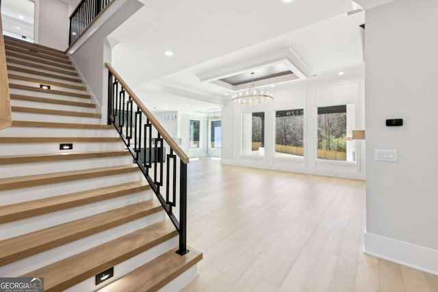 3057 Bold Springs Rd, Dacula, GA 30019 - stairway with a chandelier, a tray ceiling, and wood finished floors