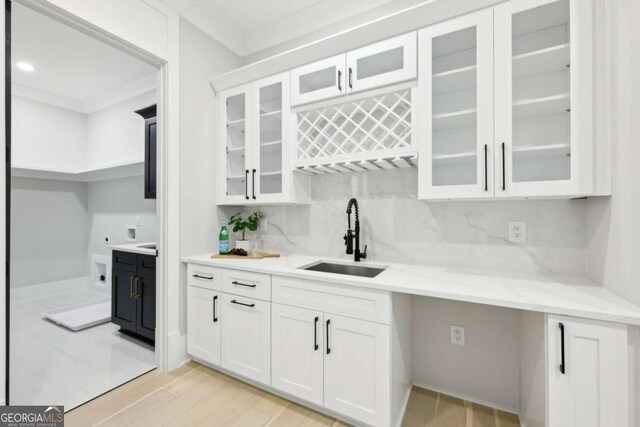 3057 Bold Springs Rd, Dacula, GA 30019 - bar featuring light wood-style flooring, a sink, tasteful backsplash, crown molding, and indoor wet bar