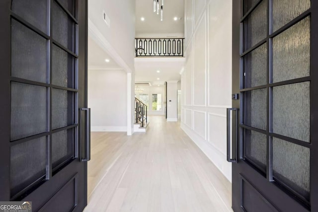3057 Bold Springs Rd, Dacula, GA 30019 - entrance foyer featuring visible vents, baseboards, a towering ceiling, a decorative wall, and light wood-type flooring