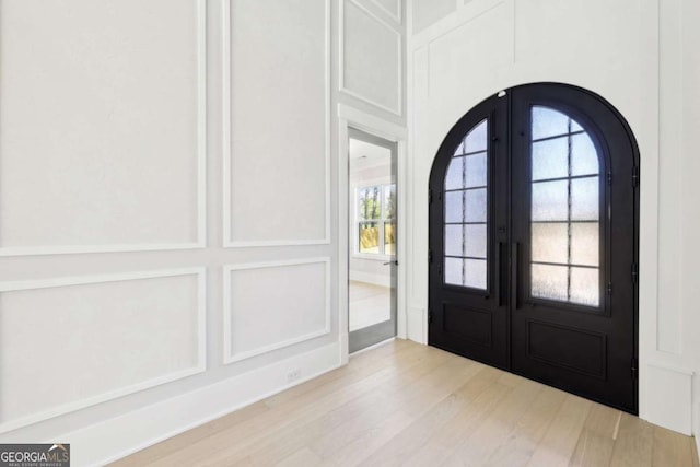 3057 Bold Springs Rd, Dacula, GA 30019 - entryway with arched walkways, a decorative wall, french doors, and wood finished floors