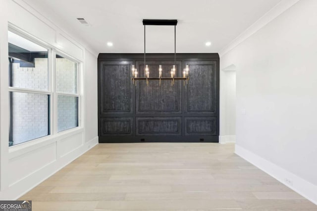 3057 Bold Springs Rd, Dacula, GA 30019 - unfurnished dining area featuring a decorative wall, crown molding, light wood finished floors, baseboards, and a chandelier