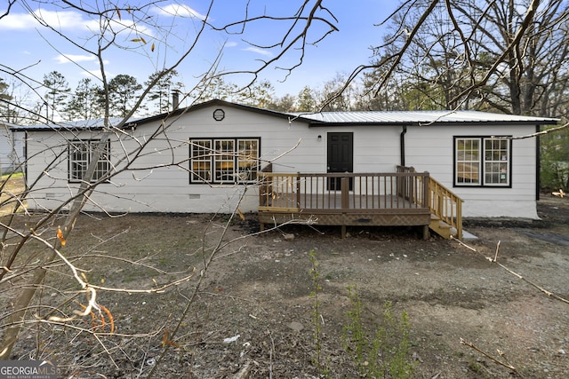 back of house featuring metal roof and a deck