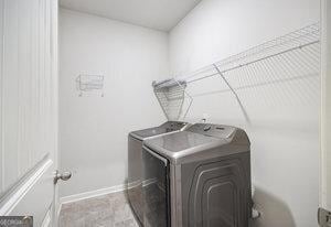 clothes washing area featuring laundry area, separate washer and dryer, and baseboards