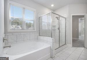 full bath featuring tile patterned floors, a stall shower, and a garden tub