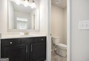 bathroom with vanity, toilet, and visible vents