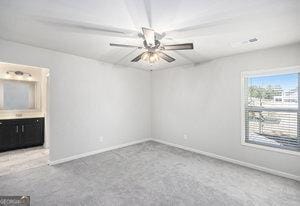 spare room with baseboards, ceiling fan, and carpet flooring