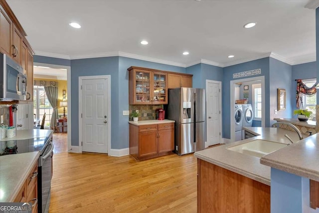 16 Quarter Horse Dr NW, Rome, GA 30165 - kitchen featuring a sink, brown cabinetry, light wood-type flooring, stainless steel appliances, and washing machine and dryer