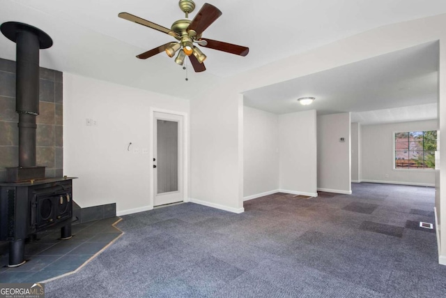 1833 Lost Mountain Rd, Powder Springs, GA 30127 - unfurnished living room featuring baseboards, carpet, a wood stove, and a ceiling fan
