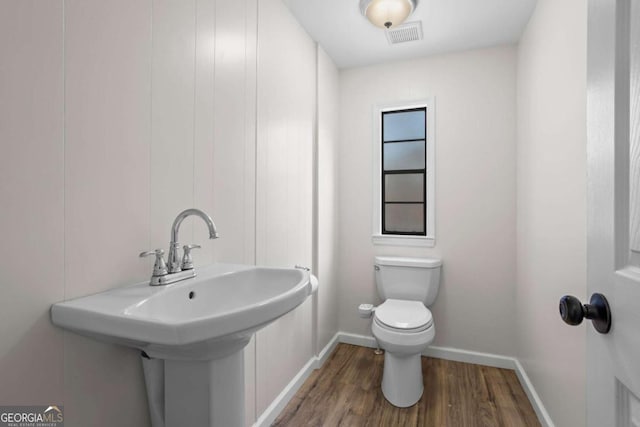 1833 Lost Mountain Rd, Powder Springs, GA 30127 - half bathroom featuring toilet, wood finished floors, baseboards, and a sink