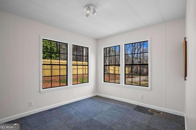 1833 Lost Mountain Rd, Powder Springs, GA 30127 - empty room with visible vents, plenty of natural light, baseboards, and dark carpet