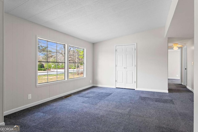 1833 Lost Mountain Rd, Powder Springs, GA 30127 - unfurnished bedroom with dark colored carpet, visible vents, lofted ceiling, and baseboards