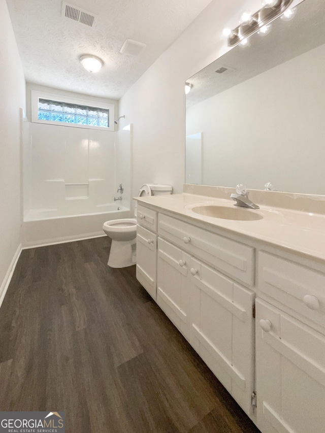 105 Creekwood Ln, Fayetteville, GA 30214 - bathroom featuring visible vents, toilet, a textured ceiling, wood finished floors, and  shower combination