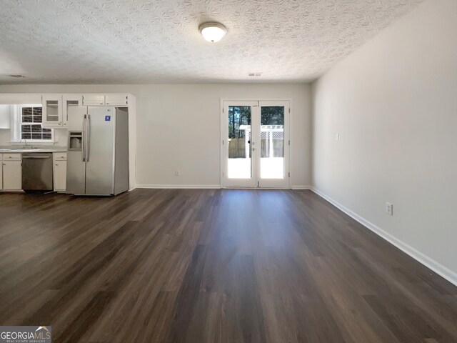 105 Creekwood Ln, Fayetteville, GA 30214 - unfurnished living room featuring dark wood-style floors, visible vents, a textured ceiling, and baseboards