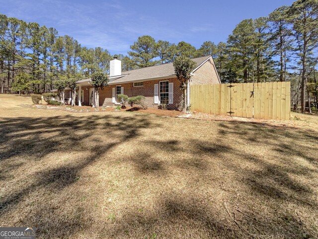 105 Creekwood Ln, Fayetteville, GA 30214 - view of home's exterior featuring brick siding, a chimney, and fence
