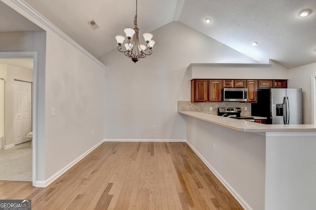 kitchen featuring visible vents, lofted ceiling, light countertops, appliances with stainless steel finishes, and a notable chandelier