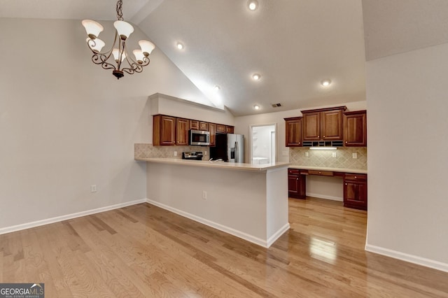 kitchen with stainless steel appliances, a notable chandelier, light wood-style flooring, and light countertops