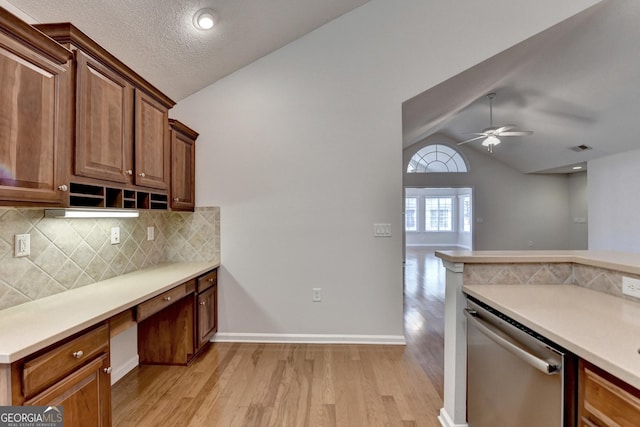 kitchen with light wood finished floors, light countertops, lofted ceiling, a ceiling fan, and stainless steel dishwasher