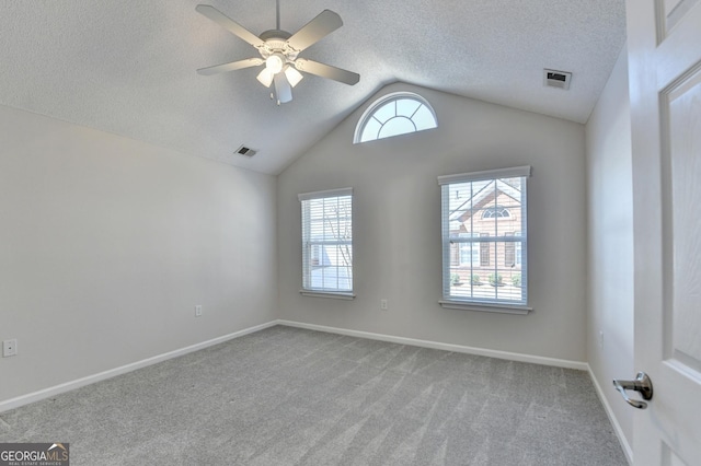 spare room with visible vents, carpet flooring, a textured ceiling, and vaulted ceiling